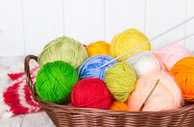 Wicker basket with colorful balls of yarn