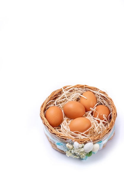 wicker basket with eggs on a white background