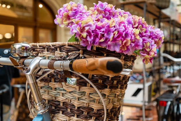 Wicker basket with flowers attached to bicycle handlebar