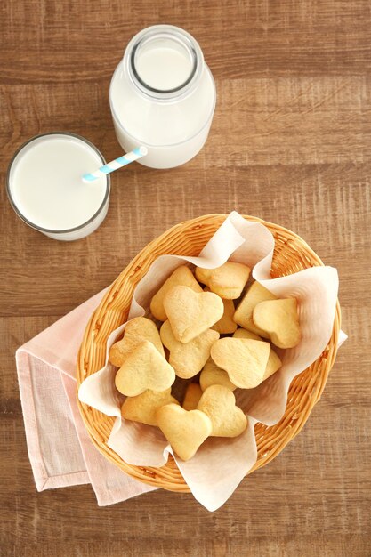 Wicker basket with heart shaped butter cookies on table