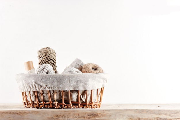 Photo wicker basket with yarn and thread on a white background isolated