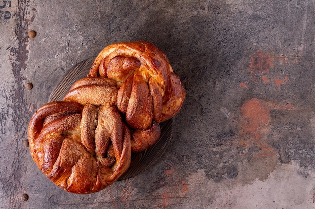 Wicker bun made of wheat flour lies on a round wooden board copy space