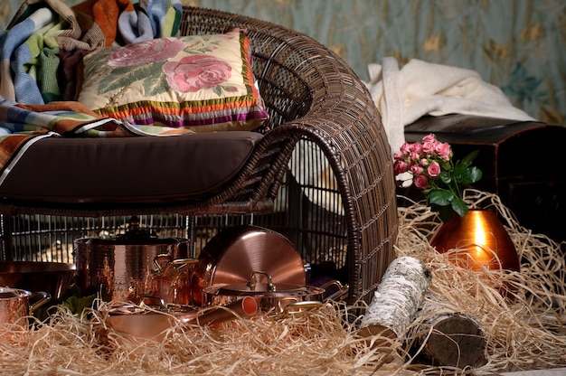 Wicker chair with a pillow and bronze metal dishes