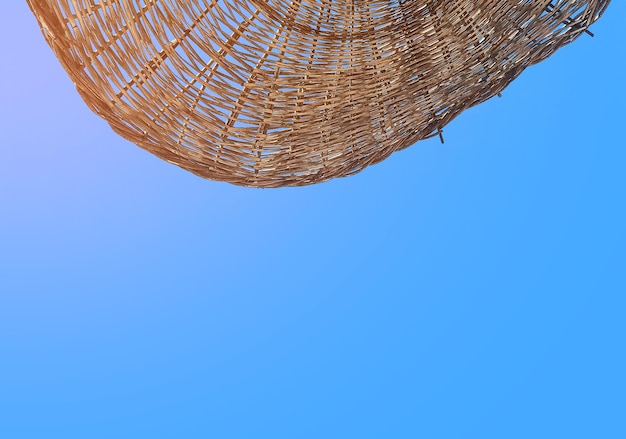 Wicker deck chair on background of blue sky