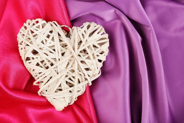 Wicker heart on fabric background