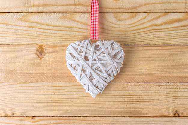wicker heart made of straw on wooden background