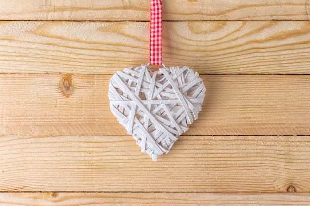 Wicker heart made of straw on wooden background