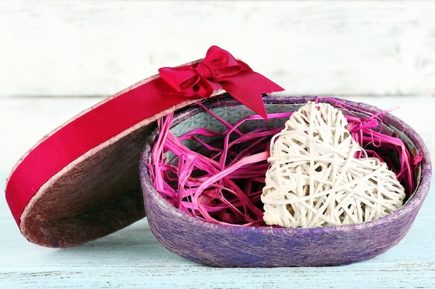 Wicker heart in present box on wooden table