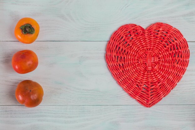 Cuore rosso del tubo di carta di vimini su tavole di legno bianche amore e concetto di matrimonio sfondo di san valentino