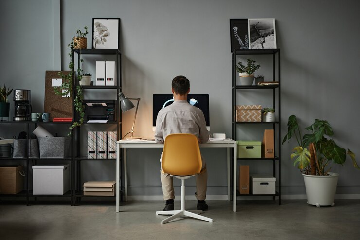 Photo wide angle back view at man using computer at home office with modern tech interior copy space