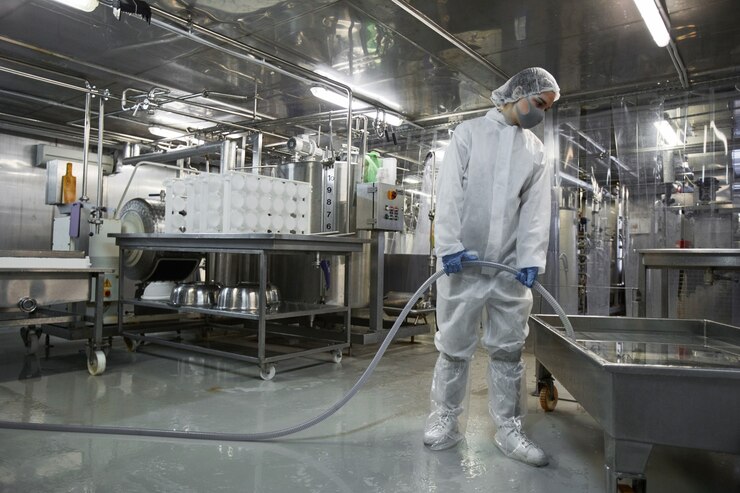 Photo クリーンフード製造工場、コピースペースで機器を洗う女性労働者の広角全身肖像画