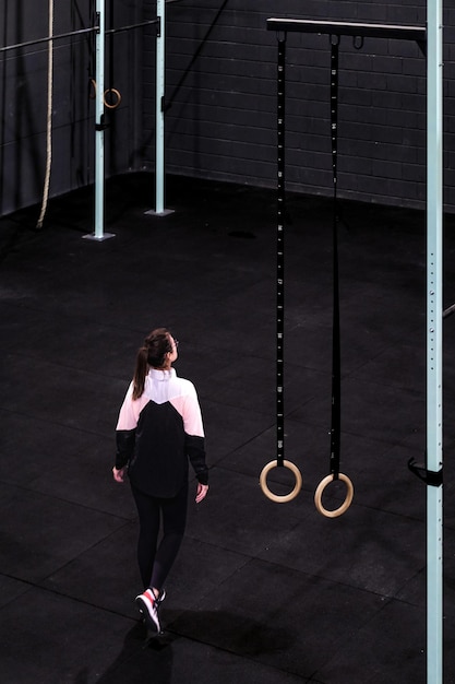 A wide angle picture of woman entering to a modern and industrial gym