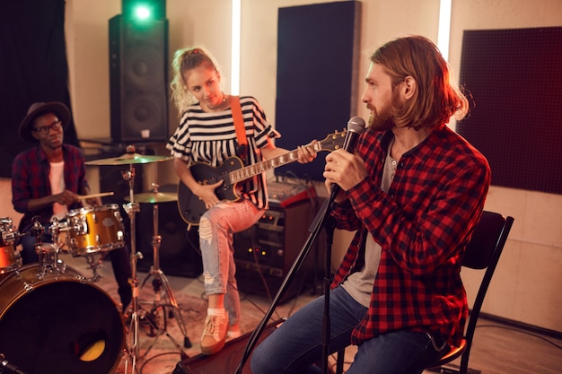 Wide angle portrait of contemporary band playing music during rehearsal