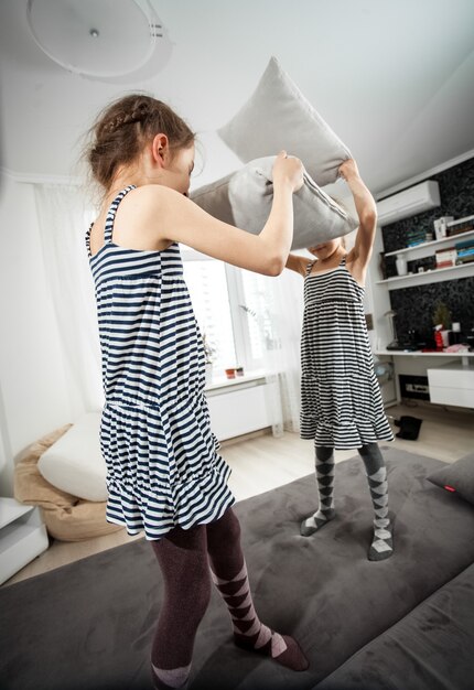 Wide angle shot of girls fighting with pillows