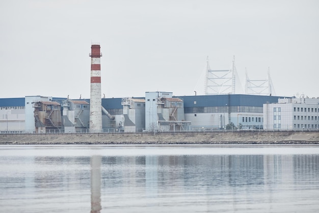 Wide angle view at industrial production factory by water copy space