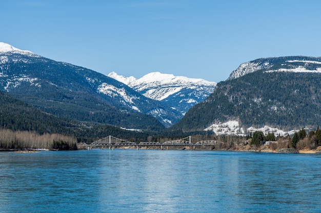 Wide Columbia river with snow in mountains blue sky early spring British Columbia Canada