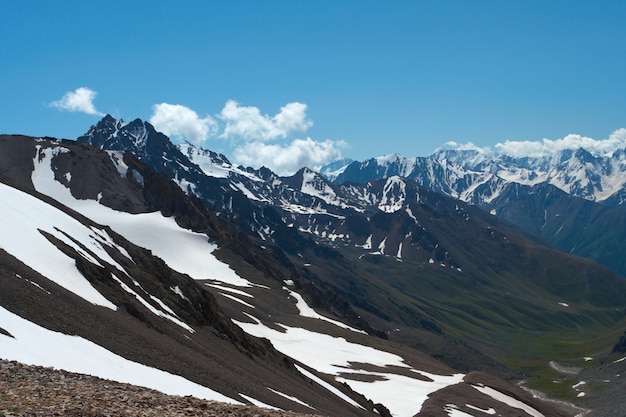 Широкая зеленая долина и горы, река с облаками, небо на расстоянии