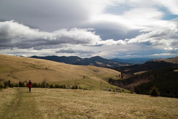 Wide mountain hillside with hiker and houses landscape photo