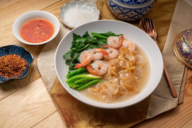 Wide Rice Noodles with Shrimp and kale in Gravy Sauce Served with chili powder and sugar