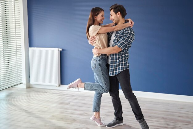 Wide shot of happy couple in new house