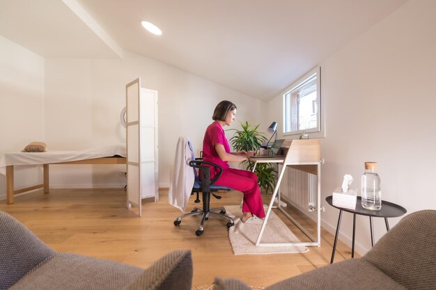 Wide view of a studio office with a nutritionist doctor working from home