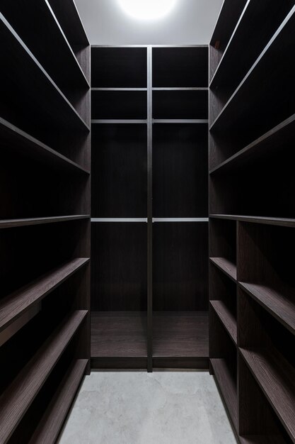 Wide wooden dressing room interior of a modern house Empty brown wooden shelves in the dressing room