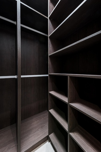 Wide wooden dressing room interior of a modern house empty
brown wooden shelves in the dressing room