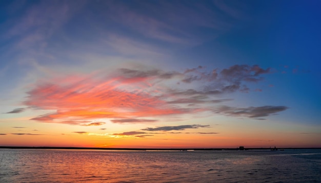 湾の向こうに沈む夕日の広角画像