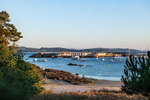 Foto vista grandangolare della spiaggia e del porto sportivo di portonovo nella ria de pontevedra al crepuscolo in spagna