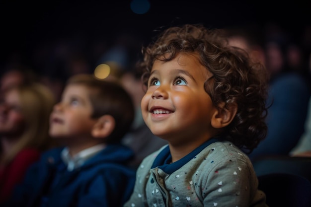 Маленький мальчик с широко открытыми глазами с удивлением смотрит на сцену во время своего первого посещения театра.