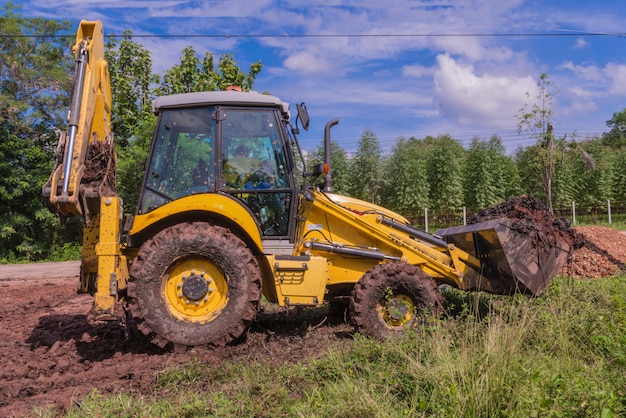 Wiellader graafmachine met backhoe laden grond op de bouwplaats.