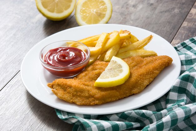 Wiener schnitzel with fried potatoes on wood