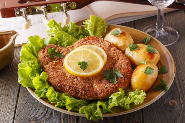 Wiener schnitzel with potatoes and salad, selective focus.