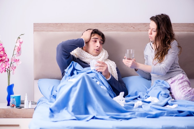 Wife caring for sick husband at home in bed