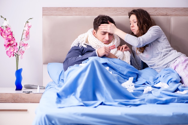 Wife caring for sick husband at home in bed