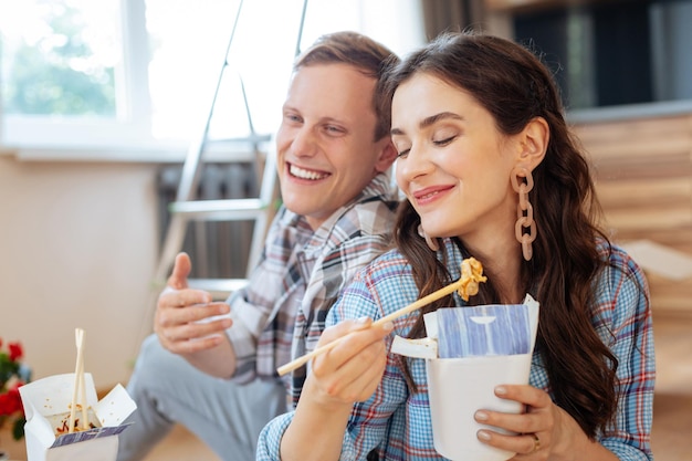 Moglie che si sente bene a mangiare deliziose tagliatelle con il marito