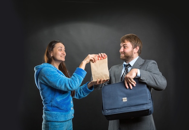 Wife giving pack with snack to her husband