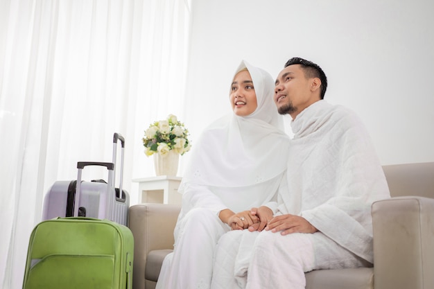 Wife and husband in white traditional clothes for Ihram