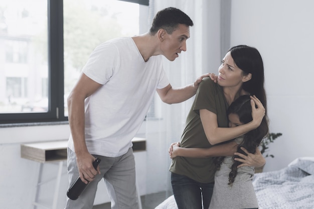 Wife is in bedroom and protects, embracing her daughter 