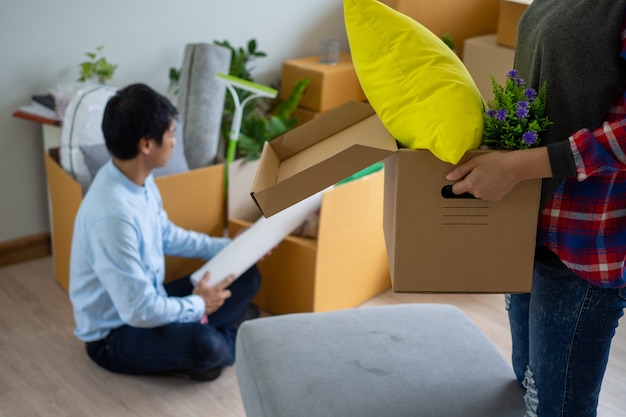 The wife is carrying the box for personal items and the husband is packing the box.