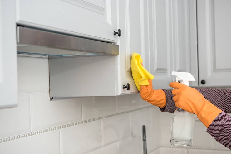 Photo wife in the kitchen wipe in yellow gloves, cleaning for care and protect yourself