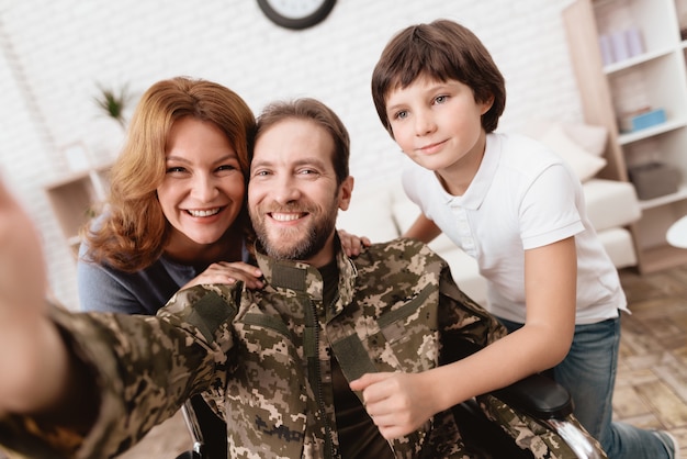 Wife and son are glad to see man and making selfie.