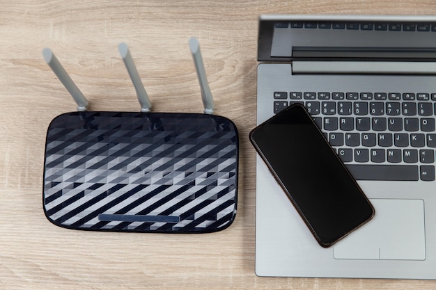 WiFi-router, smartphone en laptop op een houten tafel