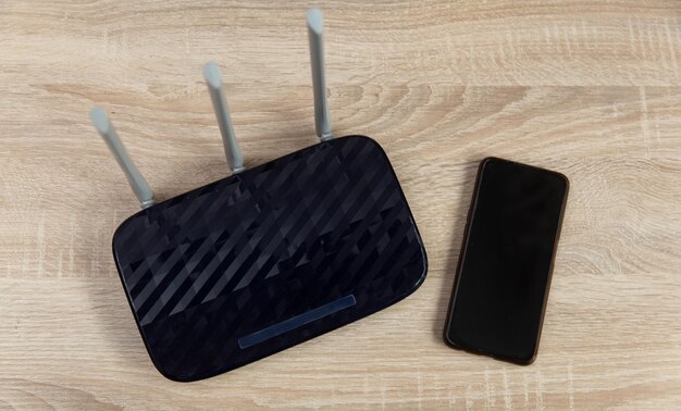 Photo wifi router and smartphone on a wooden table top view