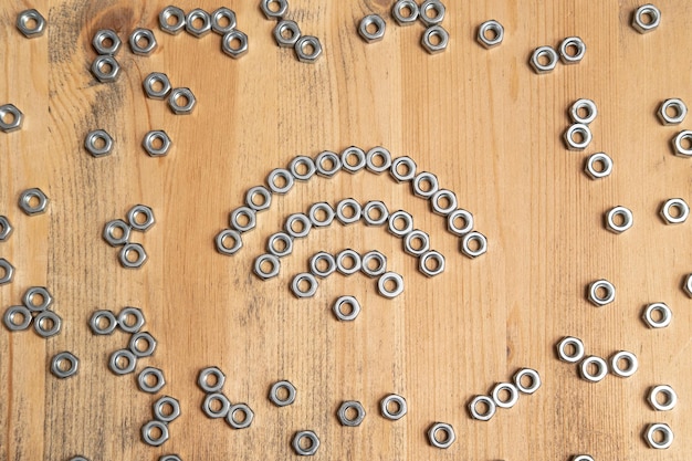 WiFi sign made of metal nuts on a wooden table