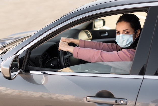 Foto wijfje dat beschermingsmasker in de auto draagt