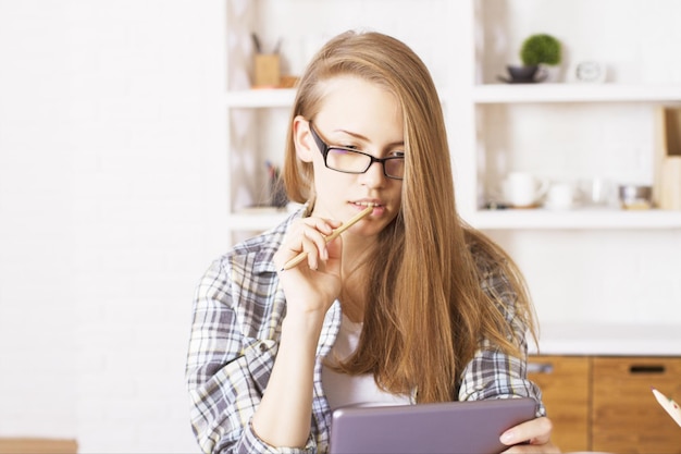 Wijfje met glazen die tablet gebruiken