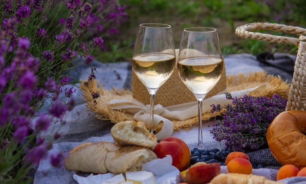 Wijn fruit bessen kaas glazen picknick in lavendelveld Selectieve focus