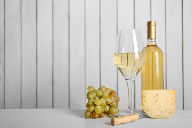 Wijn met druif en kaas op houten muurachtergrond
