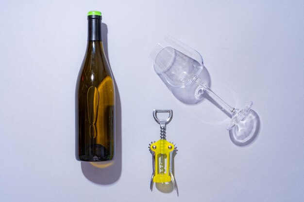 Wijnfles en glas op grijze achtergrond plat gelegd